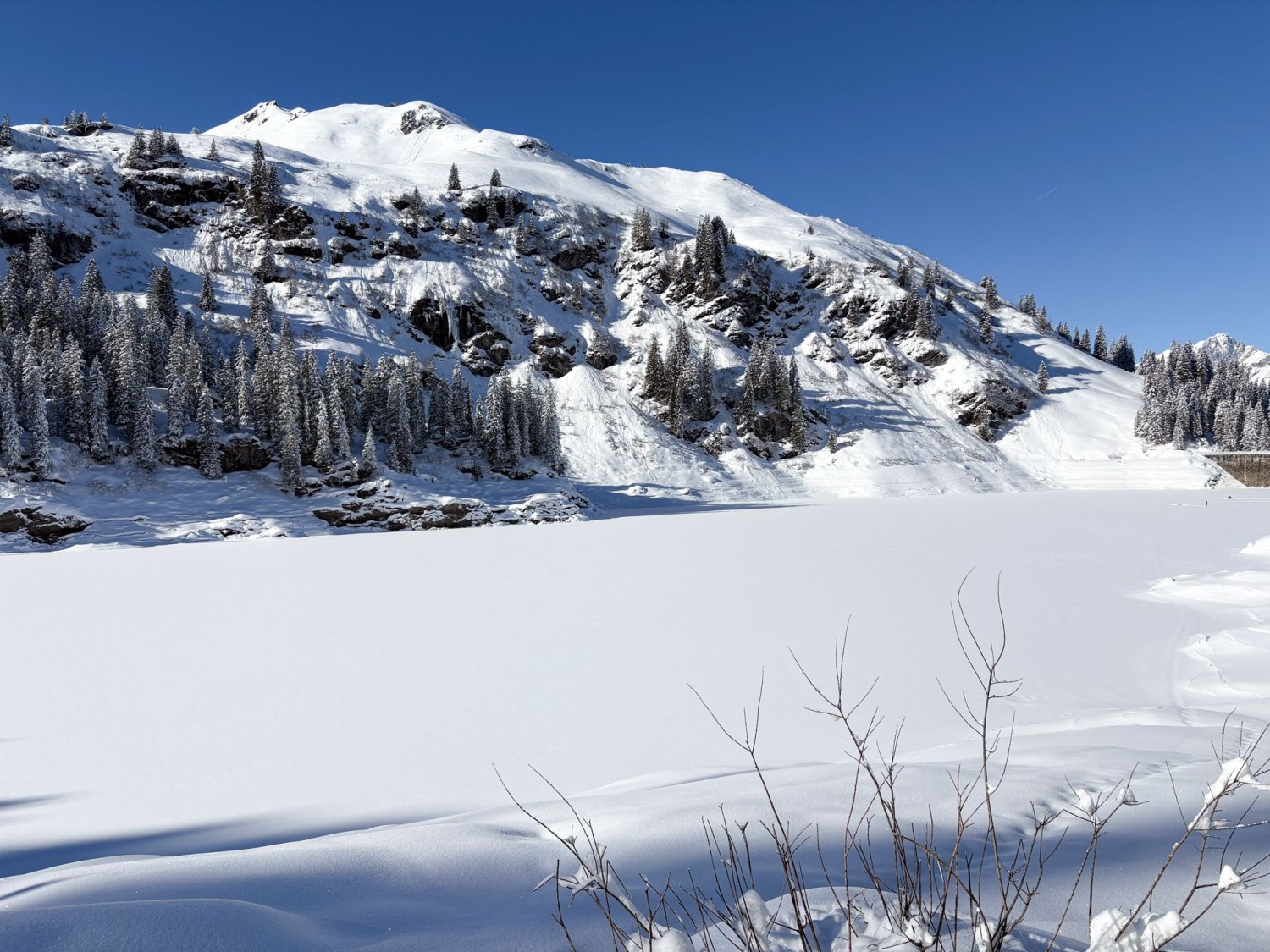 Der Stausee Garichti. Im Winter beliebt bei Eisfischern und -taucherinnen. Sie positionieren sich meistens ganz rechts im Bild nahe der Hauptmauer am Nordwestufer.